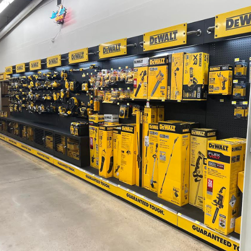 Display of DEWALT hand and power tools including circular saws, leaf blowers, chainsaws, drills, and more, all neatly organized on a display in our store.