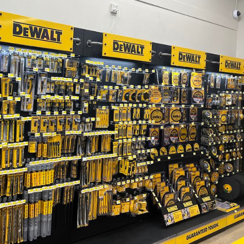 Display of DEWALT hand tools and accessories, including drill bits, saw blades, and more, all neatly organized on a store wall.